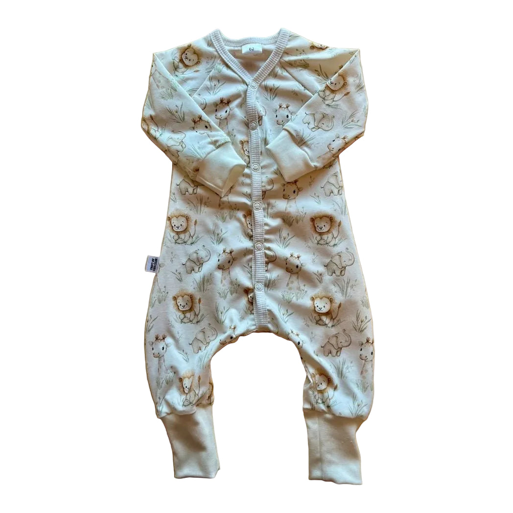 Vit pyjamas prydd med söta lejon, elefanter och giraffer i milda pastellfärger. Långa ärmar och ben och tryckknappar fram.