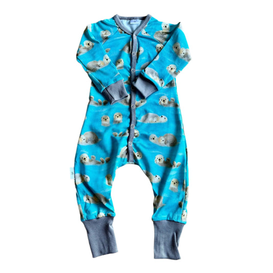 Turkos pyjamas med söta grå sälar. Grå muddar. Långa ärmar och ben samt tryckknappar. 